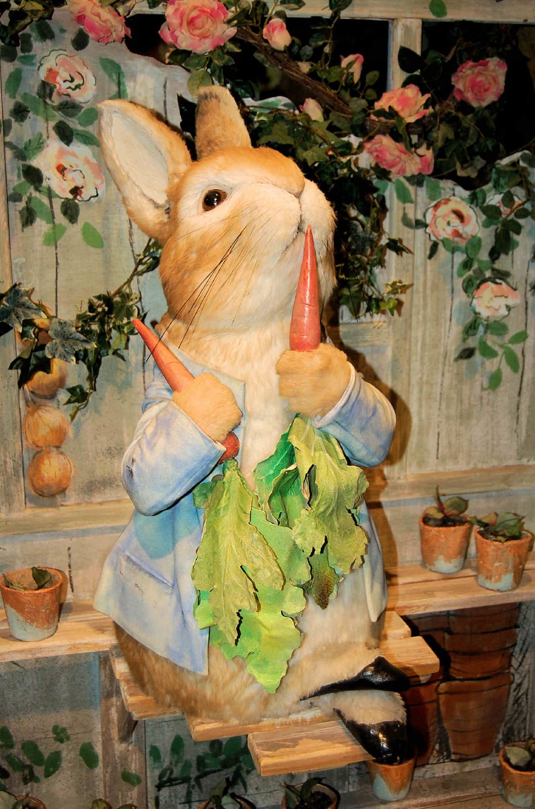 the stuffed rabbit is eating lettuce outside