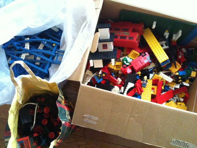 large collection of building blocks and legos are inside a cardboard box