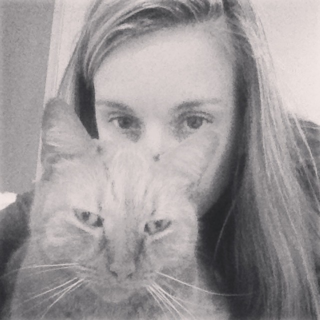 girl posing with a cat over her face