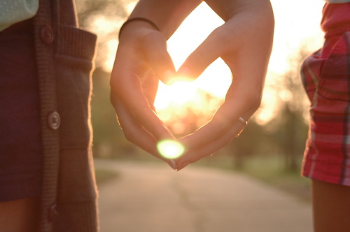 two women showing their hands in the shape of a heart