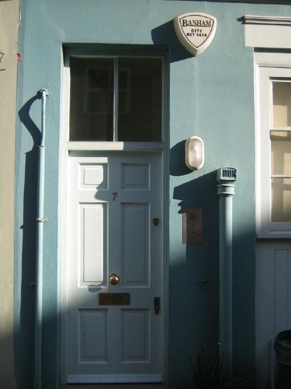 an empty door in front of the entrance of a blue house