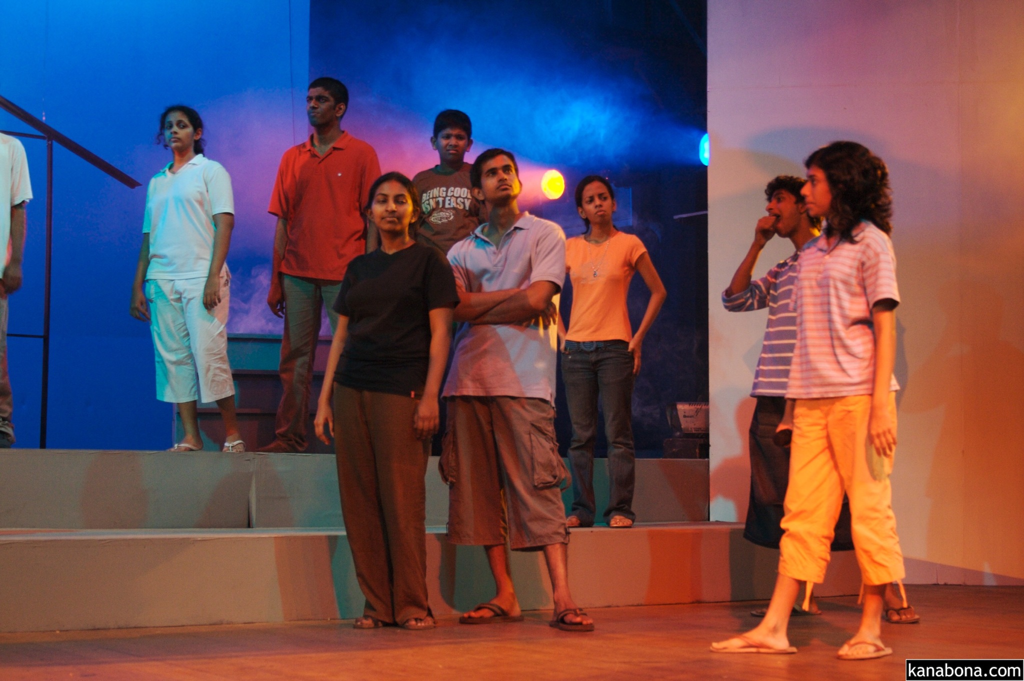 several people standing around on a stage as another person walks