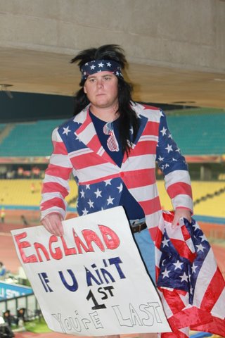 a young man in an old style costume holds a sign