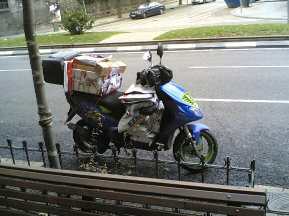 the motor bike is carrying boxes on top of it