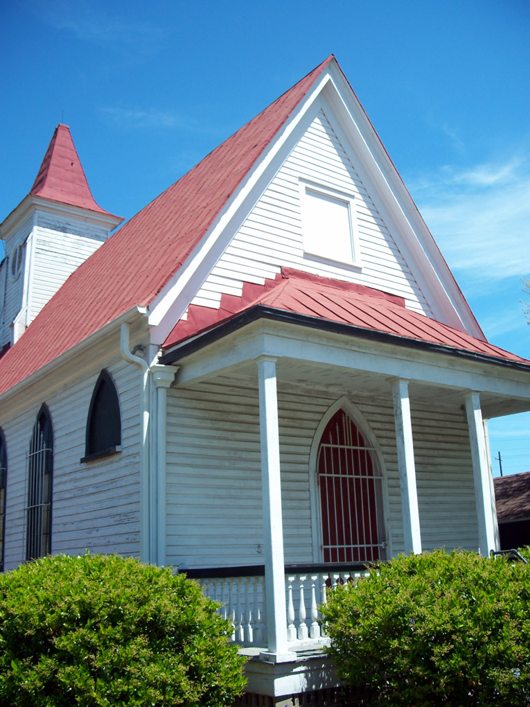 a white building with a red roof, and a red steeple