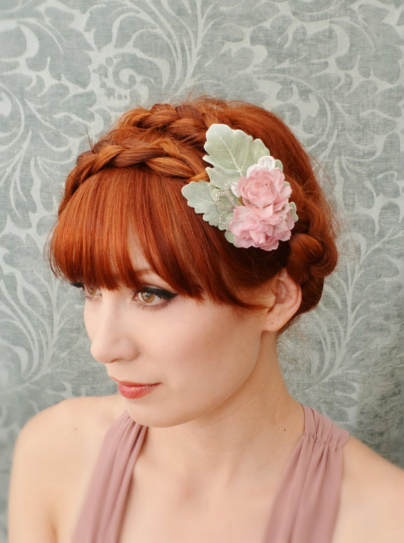 a woman with red hair has a floral head piece on top of her hair