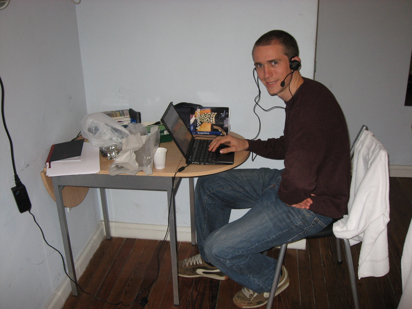 a man sitting at a desk with a laptop computer and headphones