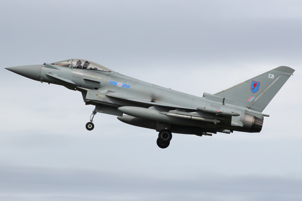 a fighter jet flying through a cloudy sky