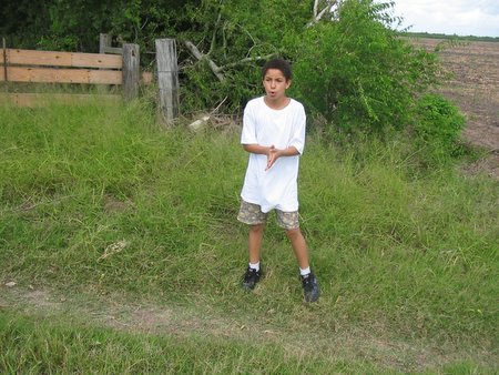 a boy in the grass poses for a picture