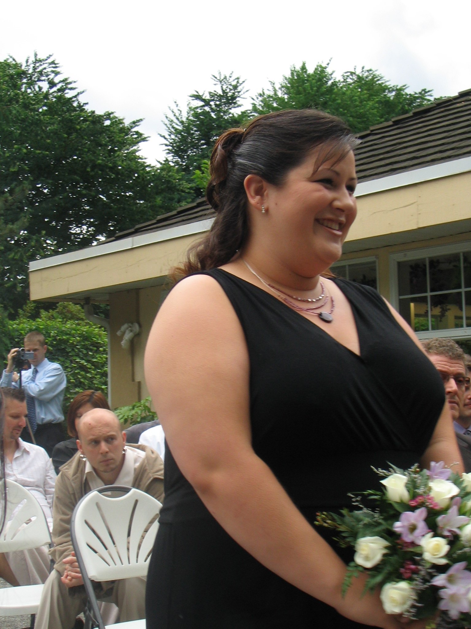 a woman is holding a bouquet at an outdoor event