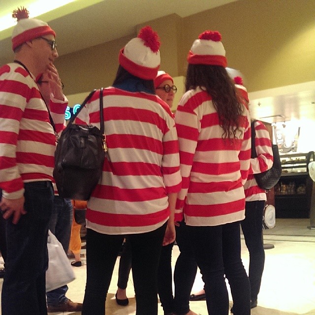 some people in red and white striped shirts are standing