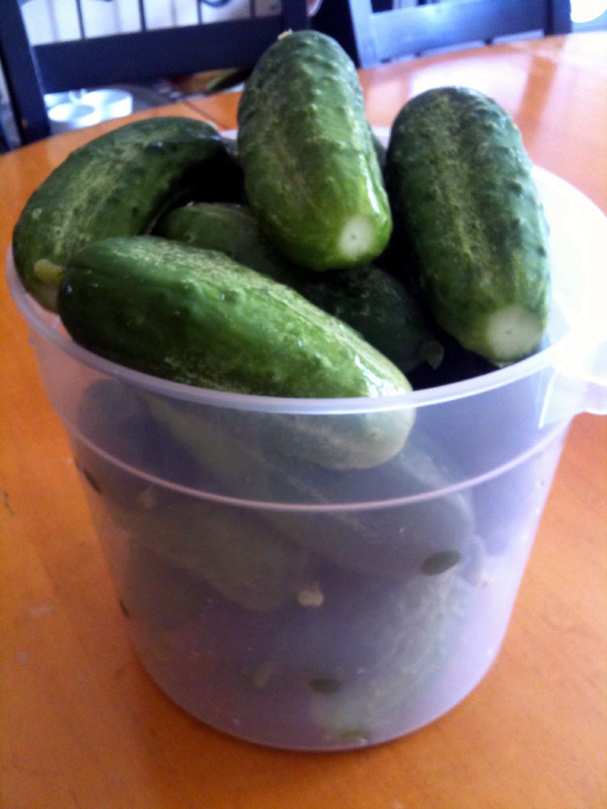 a group of pickles in a small plastic container