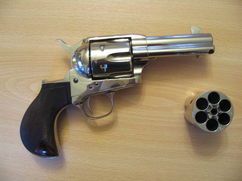 a revolver and the gun resting on a wooden table