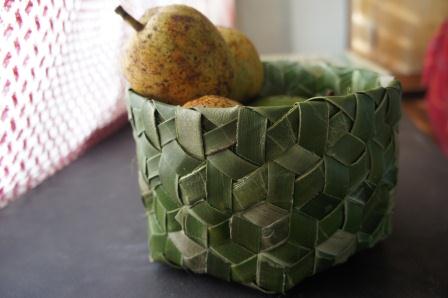 a basket with two pears in it sitting on a table