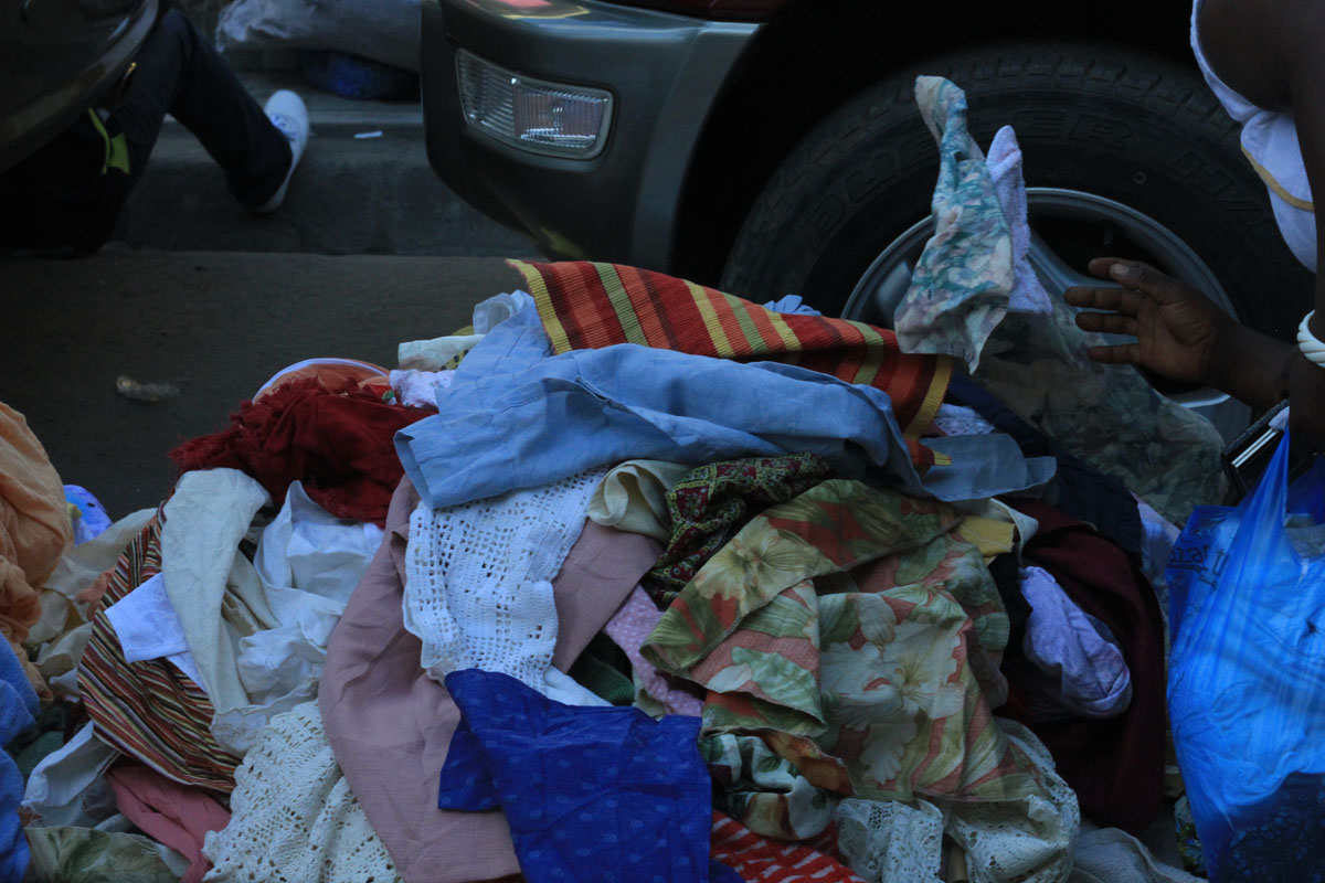 a bunch of clothes in front of a car