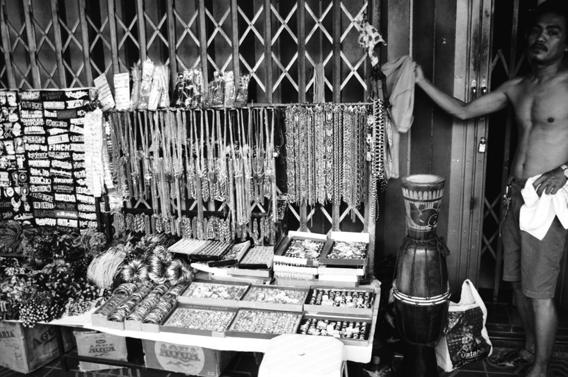 the vendor stands near all his products for sale