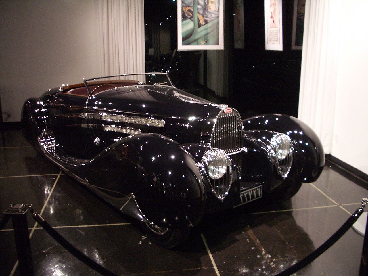 an antique black car on display inside of a museum