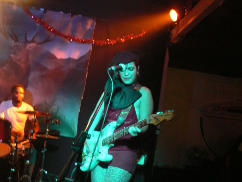 a woman singing with a guitar and playing music