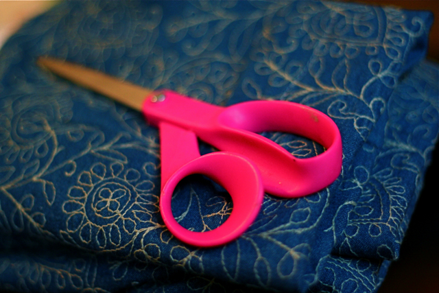 pink scissors on a purple surface
