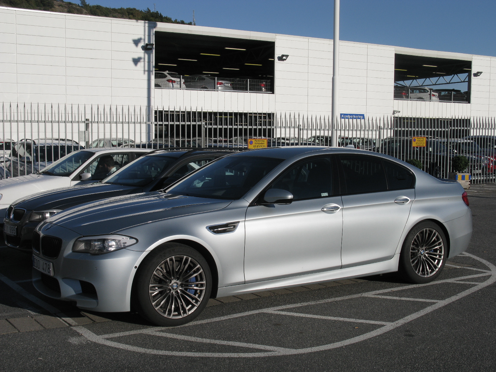 two silver cars in front of a white building