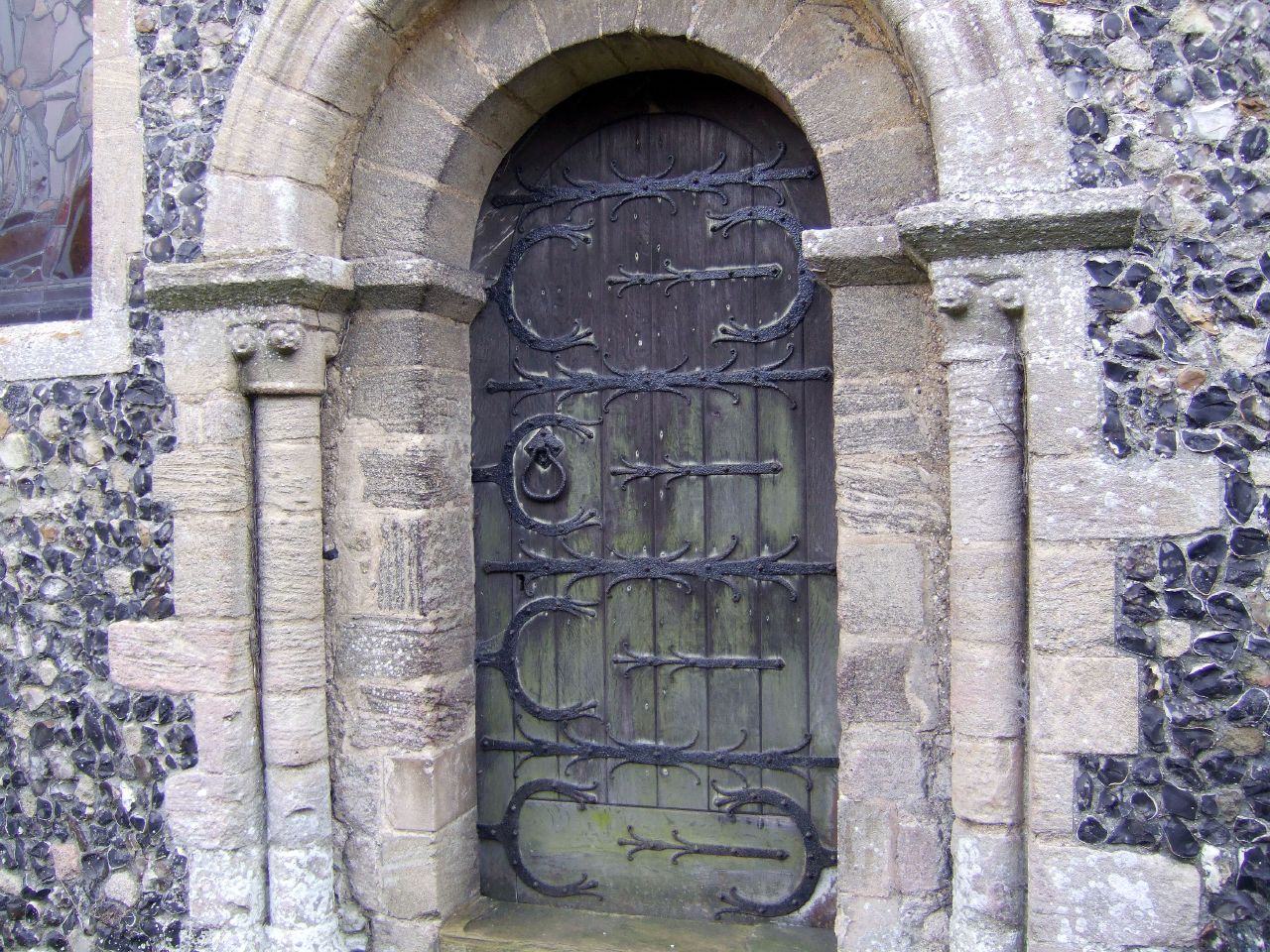 an ornate door to a church with a vine design on it