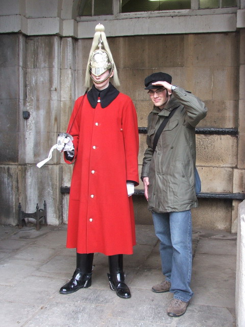 a man with a weird headdress poses next to a person dressed as a demon