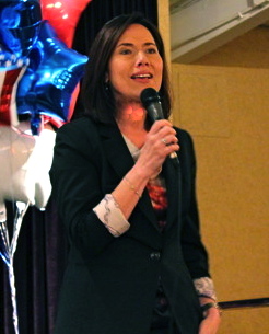 a woman standing on a stage with a microphone