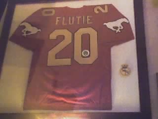 the football jersey hangs in a wooden frame