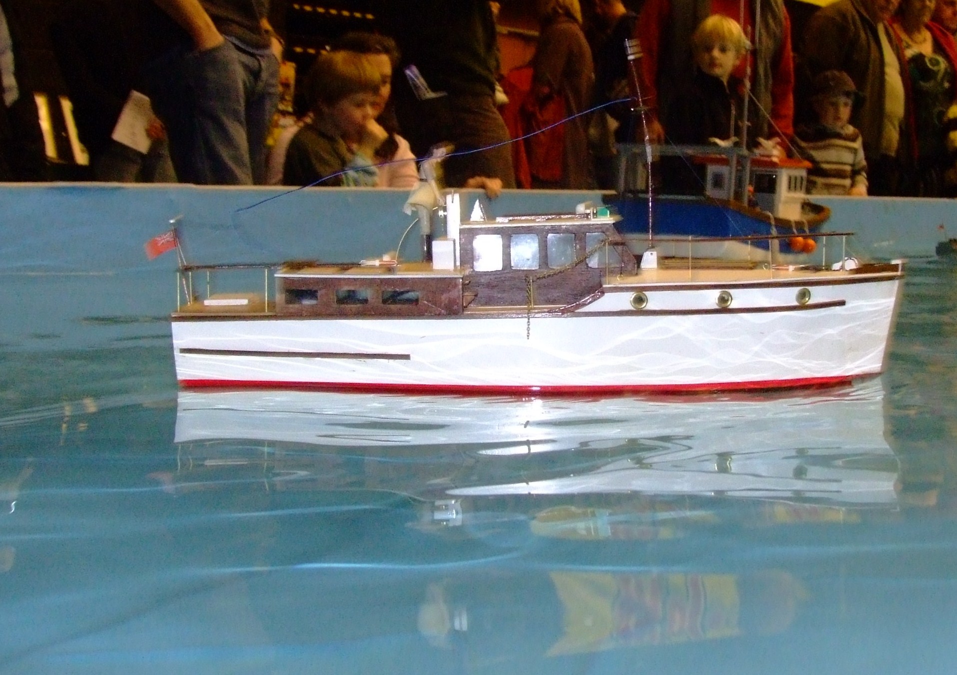 small model fishing boat in the open water at an event