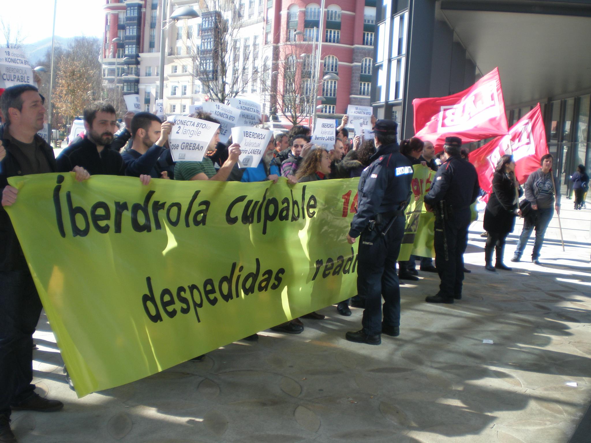 a line of protesters holding signs in spanish