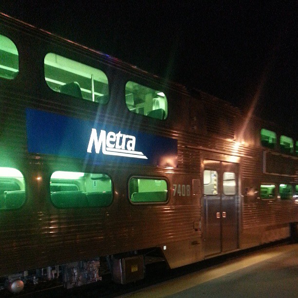 the passenger train has green lights on it's windows