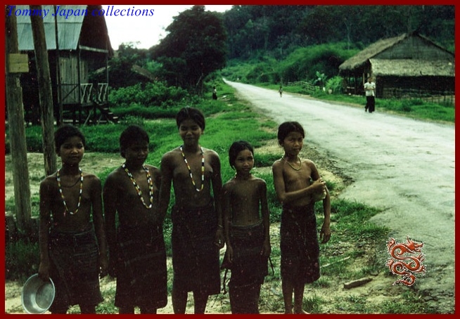 a group of young people standing next to each other on a dirt road