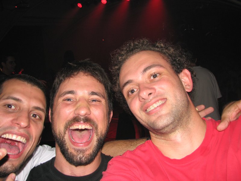 three guys posing together for the camera at a nightclub