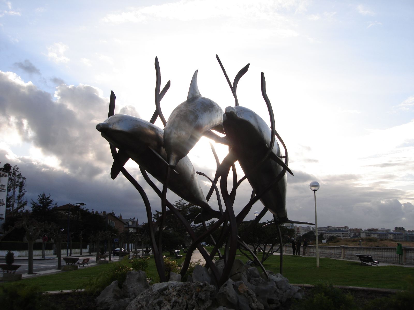 the sculptures of two dolphins are placed in the sun