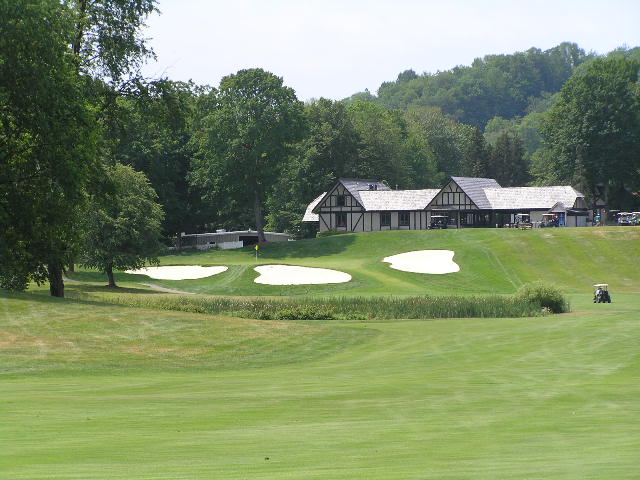 a house with several golfers on the ground by the putting green