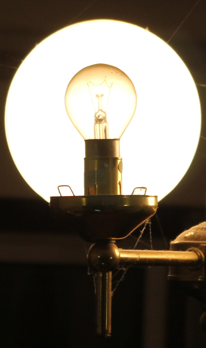 a light bulb sitting on top of a metal pole