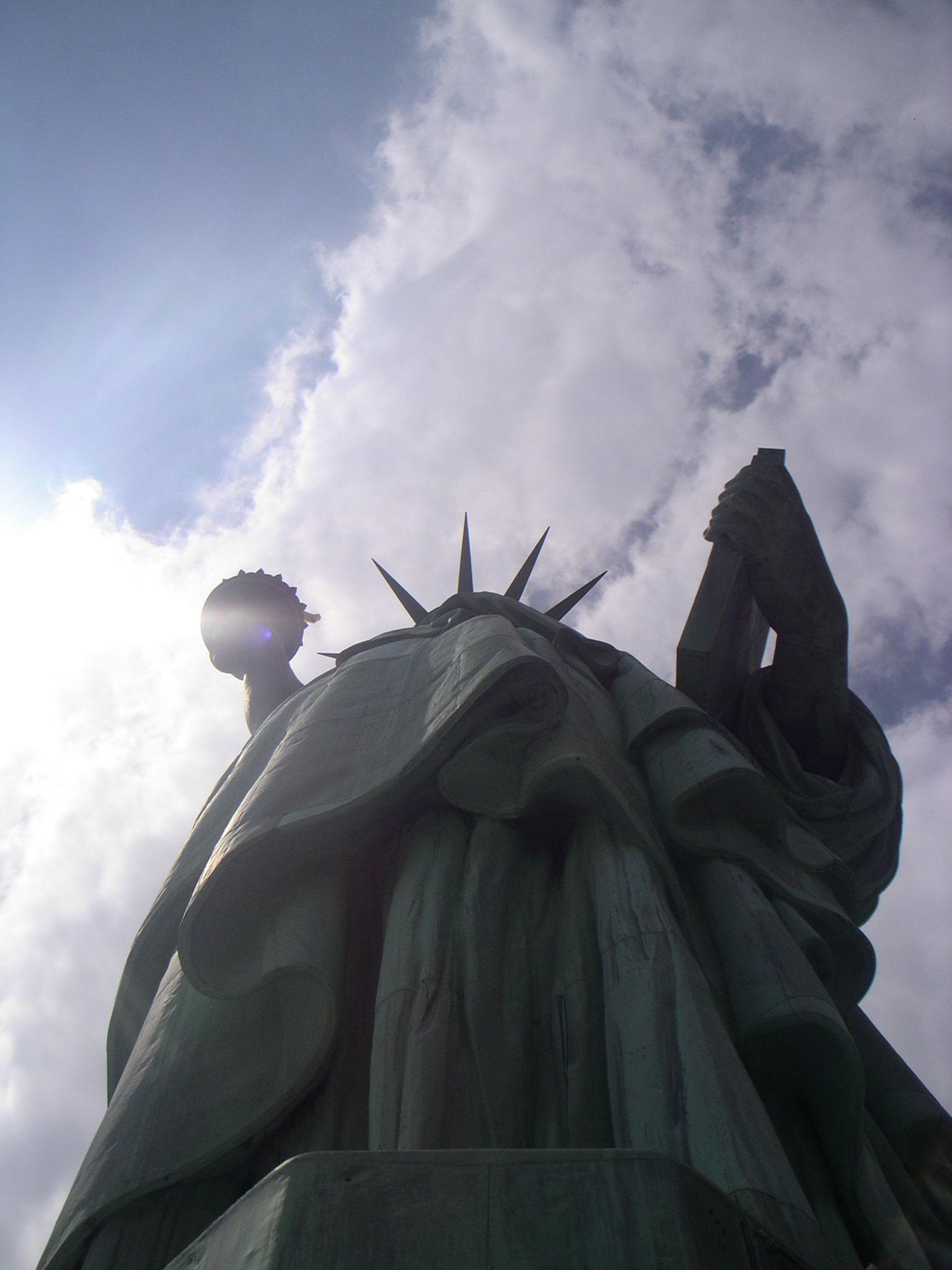 a statue is shown with the sun in the background