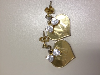 a pair of gold tone earrings with a heart - shaped cut out