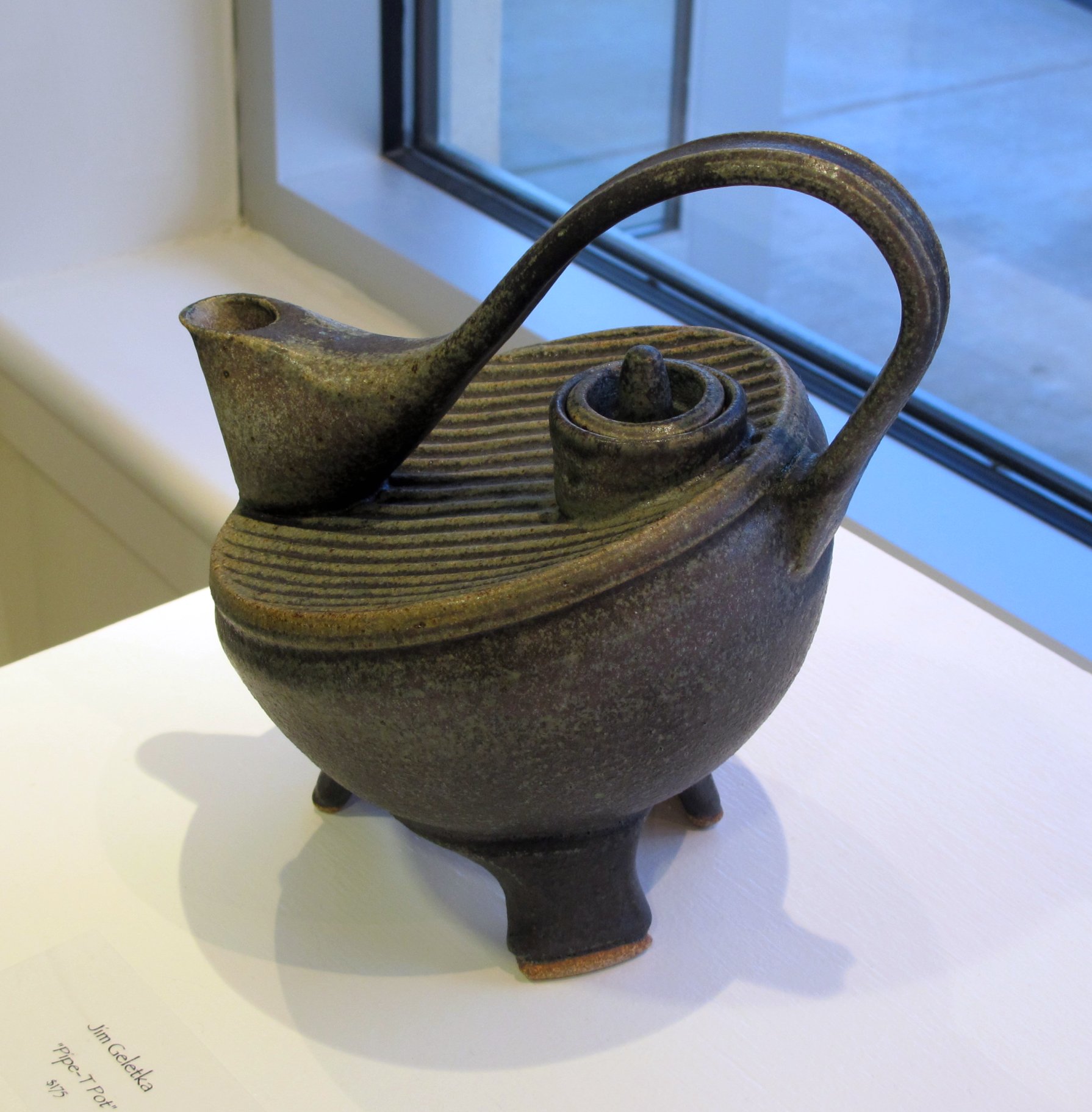 a pottery vessel is sitting on display near a window