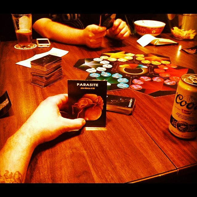a man holding a card next to a board game