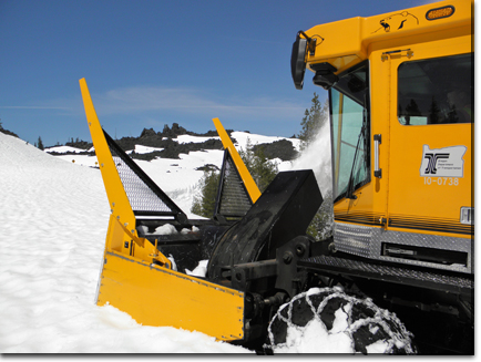 a bulldozer and another vehicle are covered with snow