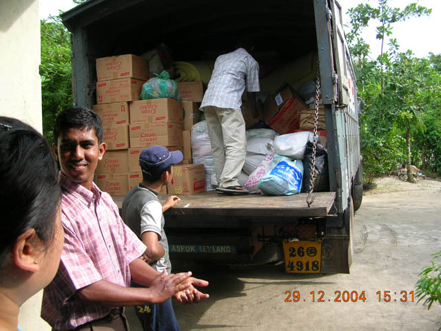 three people are gathered around in the back of a truck