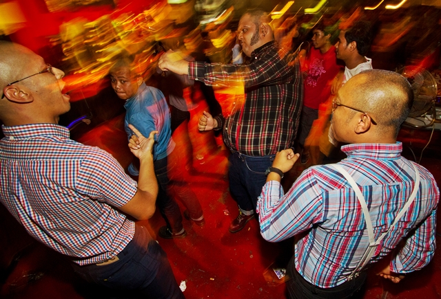 group of men on a red carpet dancing in a dance floor