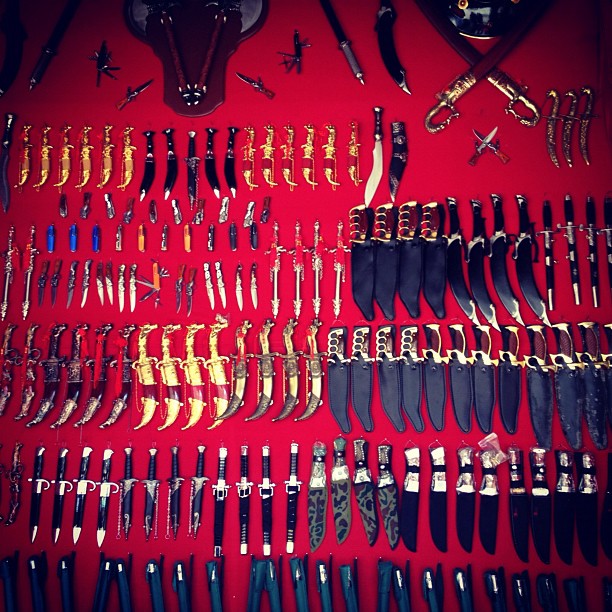 large collection of knives on red background displayed