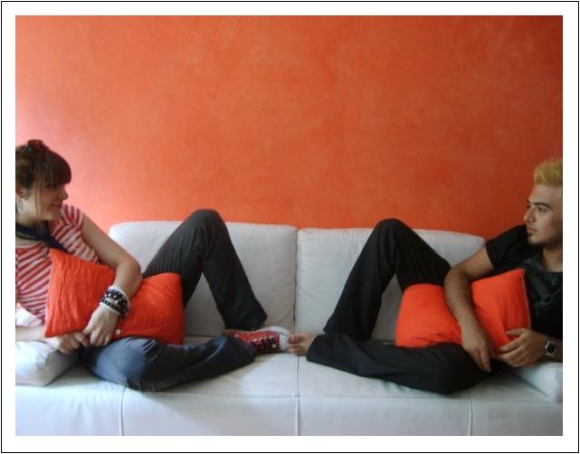 two people siting on the couch and one in black jeans