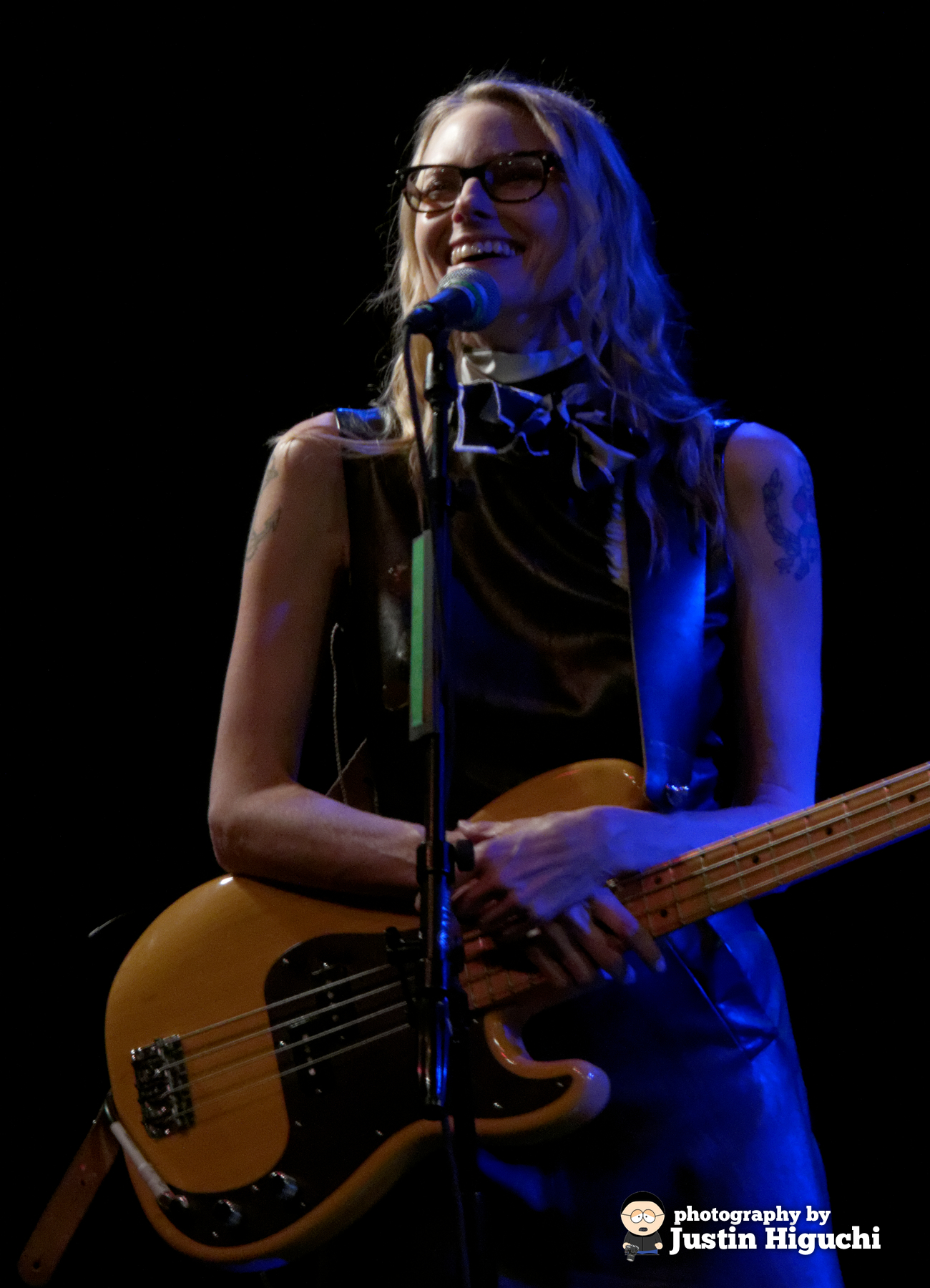 the woman is playing guitar in front of the microphone