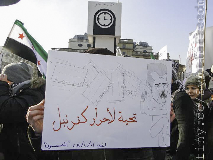 protesters hold up signs in front of a clock tower