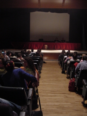 a large audience watching a lecture in an auditorium