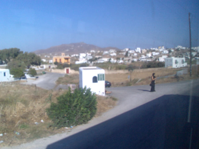 a person is walking near the road with a mobile home in the distance
