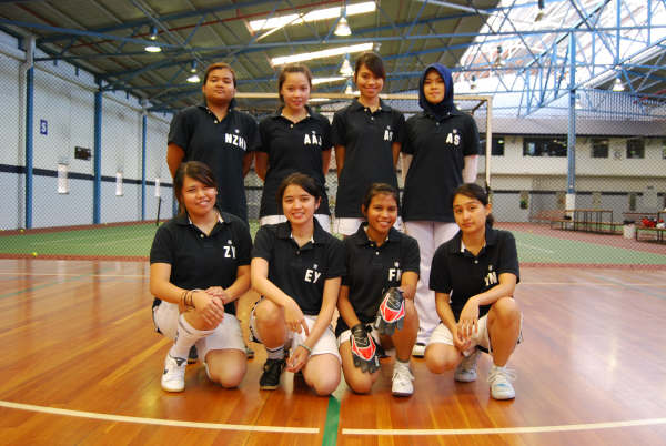 a group of girls in black are on a court